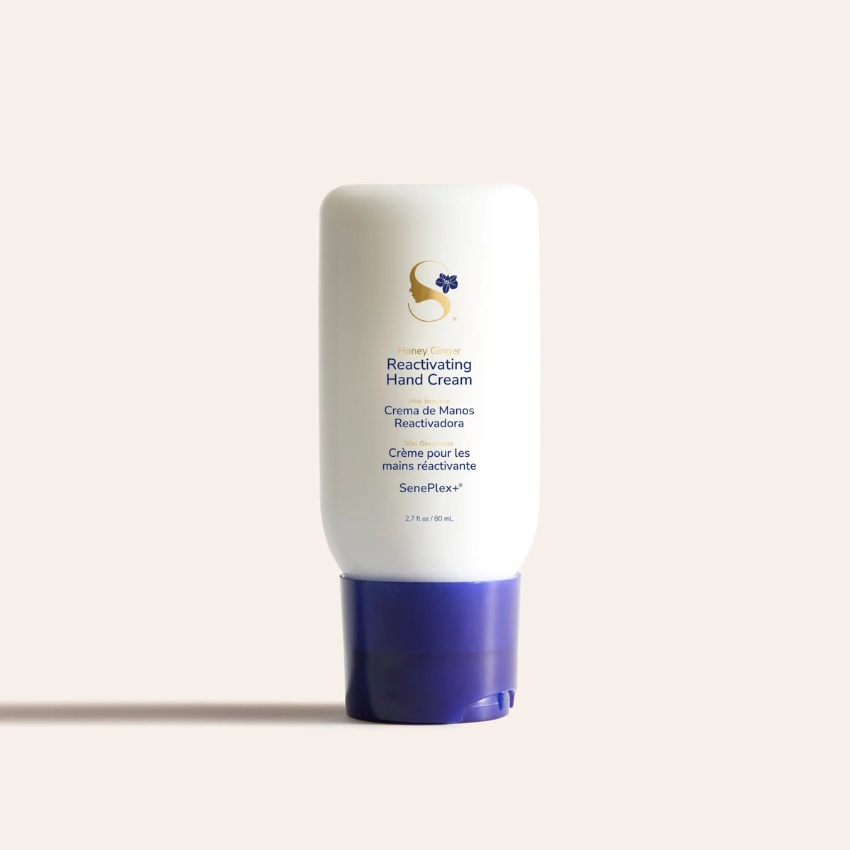 White Reactivating Hand Cream bottle with purple cap and Honey Ginger label on pale background