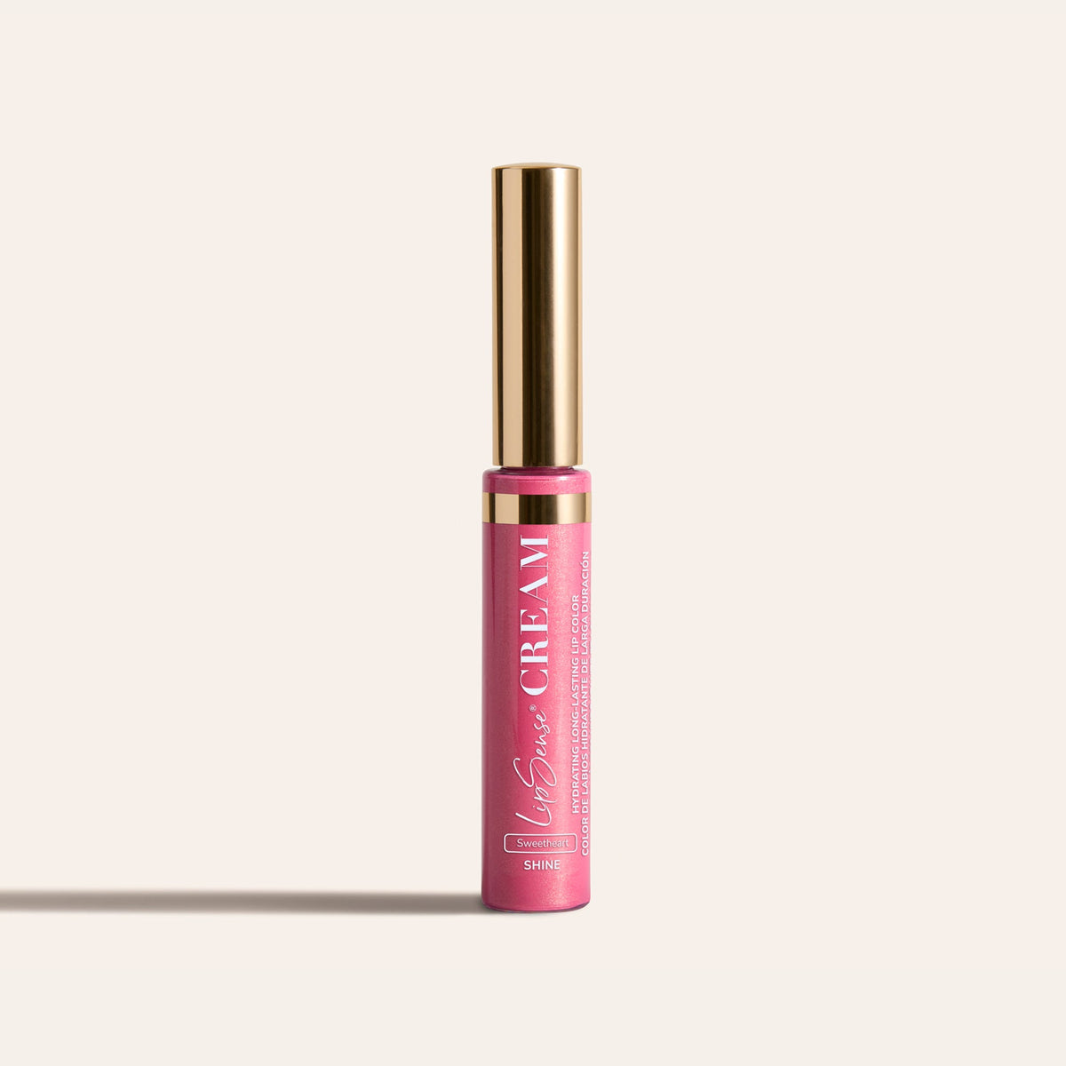 LipSense HydraMatte pink lip color bottle with a tall gold cap on a light beige background